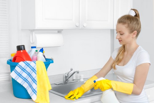 Homeowner vacuuming sofa cushions as part of routine upholstery maintenance